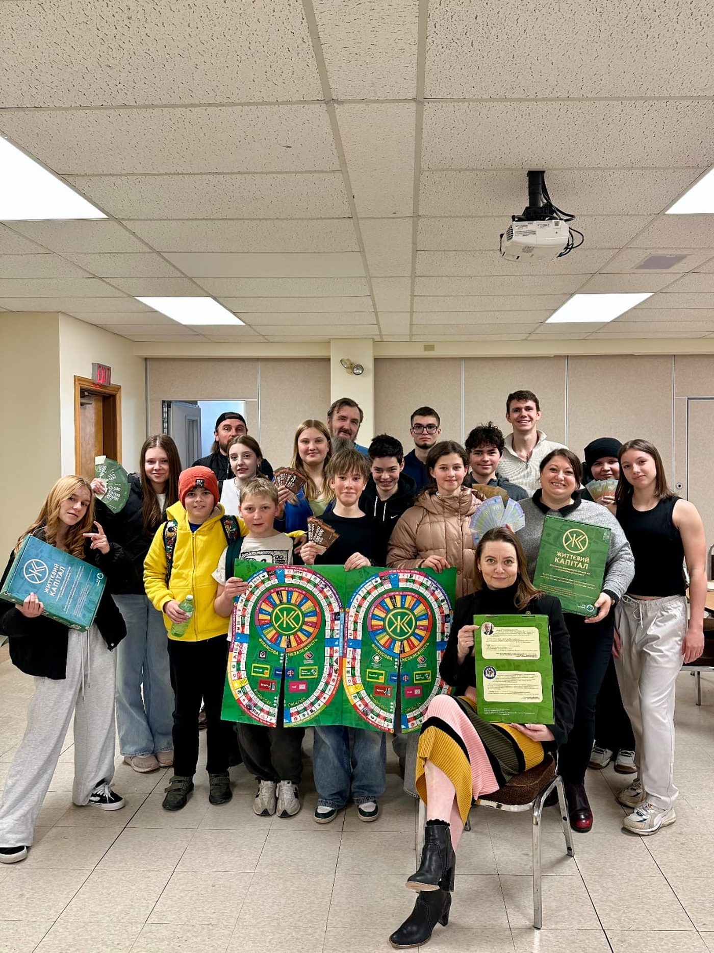 High school students holding Life Capital boards after completing their tournament simulation.